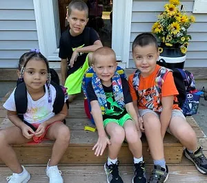 Children sitting on the front steps on their first day of school