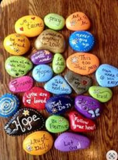 Children painting rocks at the table
